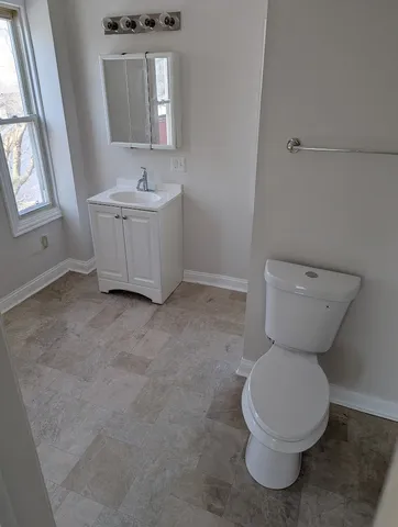 a bathroom with a toilet sink and mirror