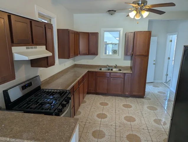 a kitchen with stainless steel appliances granite countertop a sink stove and refrigerator