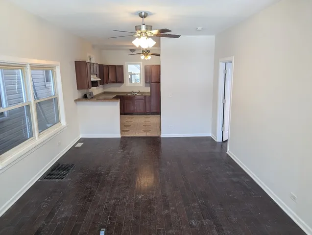 a view of a kitchen with kitchen island wooden floor and stainless steel appliances
