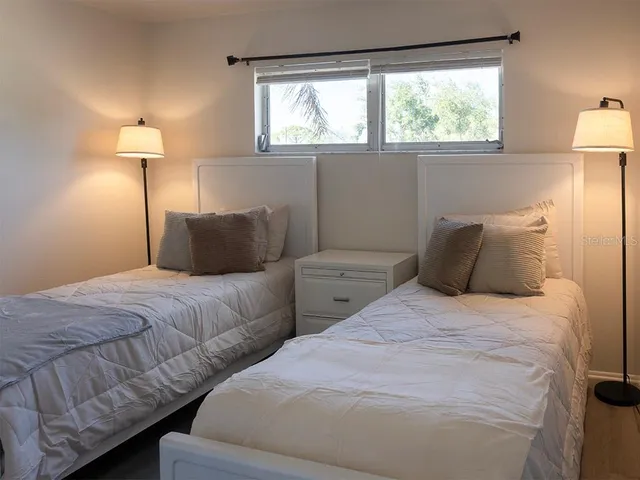 a bedroom with two beds and a night stand