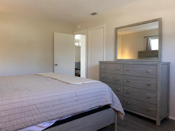 a bedroom with a bed and a mirror on dresser