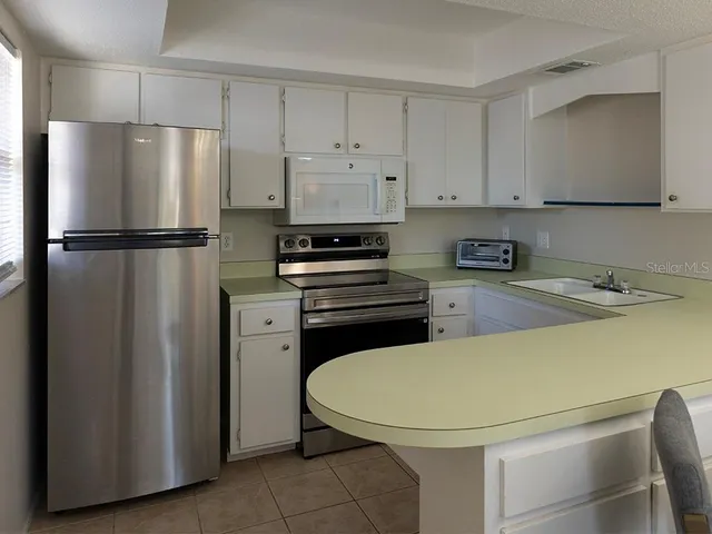 a kitchen with a refrigerator a stove and a sink