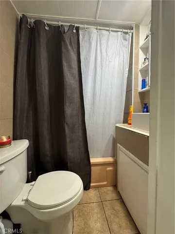a white toilet sitting next to a shower curtain