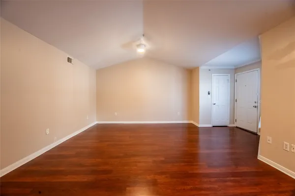 a view of an empty room with wooden floor