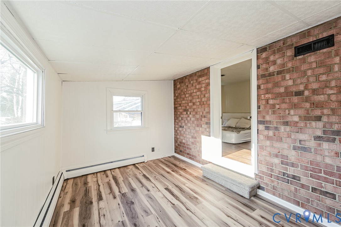 6048 Gainford Road Richmond, VA 23234 - Photo 67 of 83 Empty room with light wood finished floors, brick