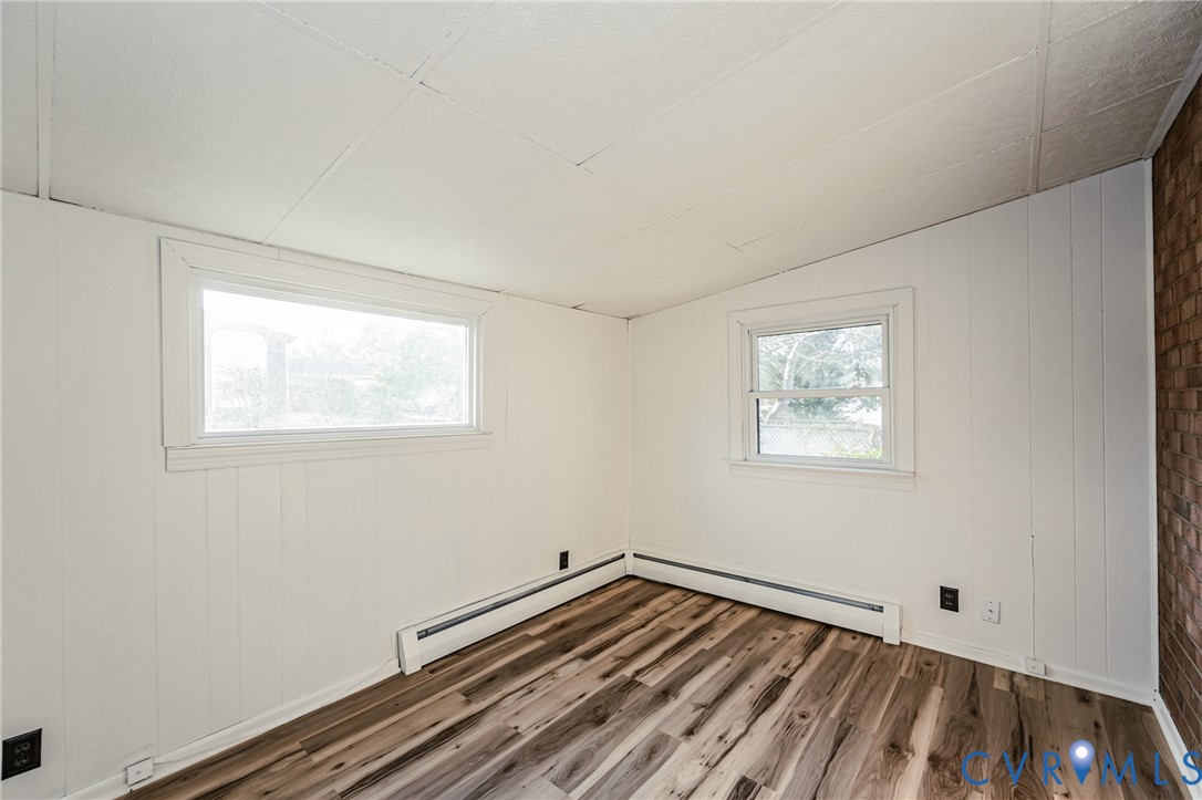 6048 Gainford Road Richmond, VA 23234 - Photo 70 of 83 Empty room with dark wood finished floors, vaulted