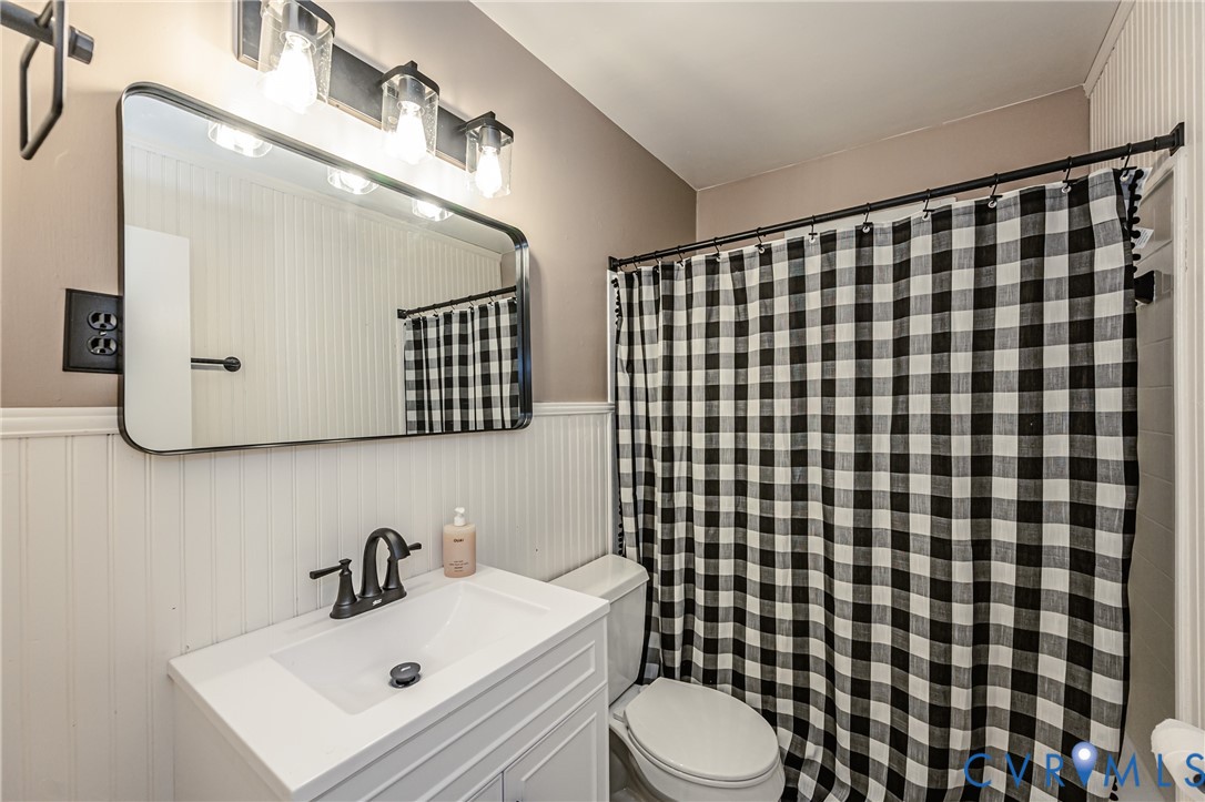 6048 Gainford Road Richmond, VA 23234 - Photo 73 of 83 Bathroom with vanity, wainscoting, and curtained s