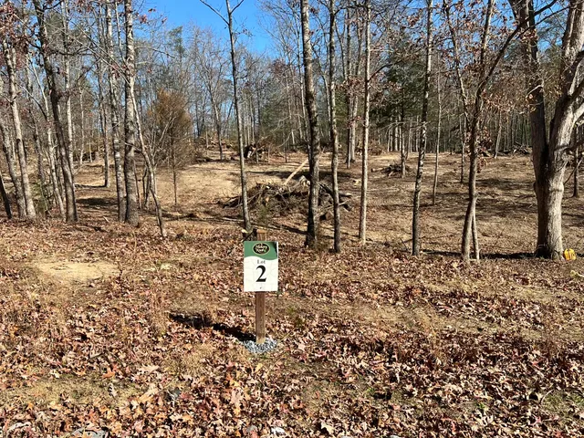 a blue sign board with tall trees