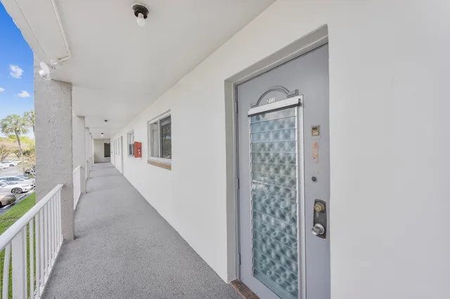 a view of a hallway to rooms and stairs