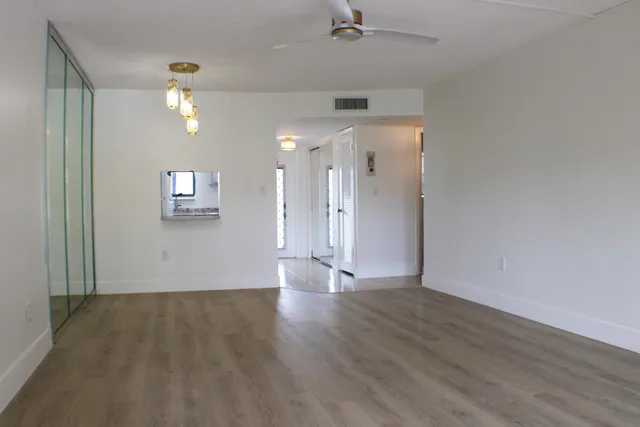 a living room with furniture a chandelier and a dining room