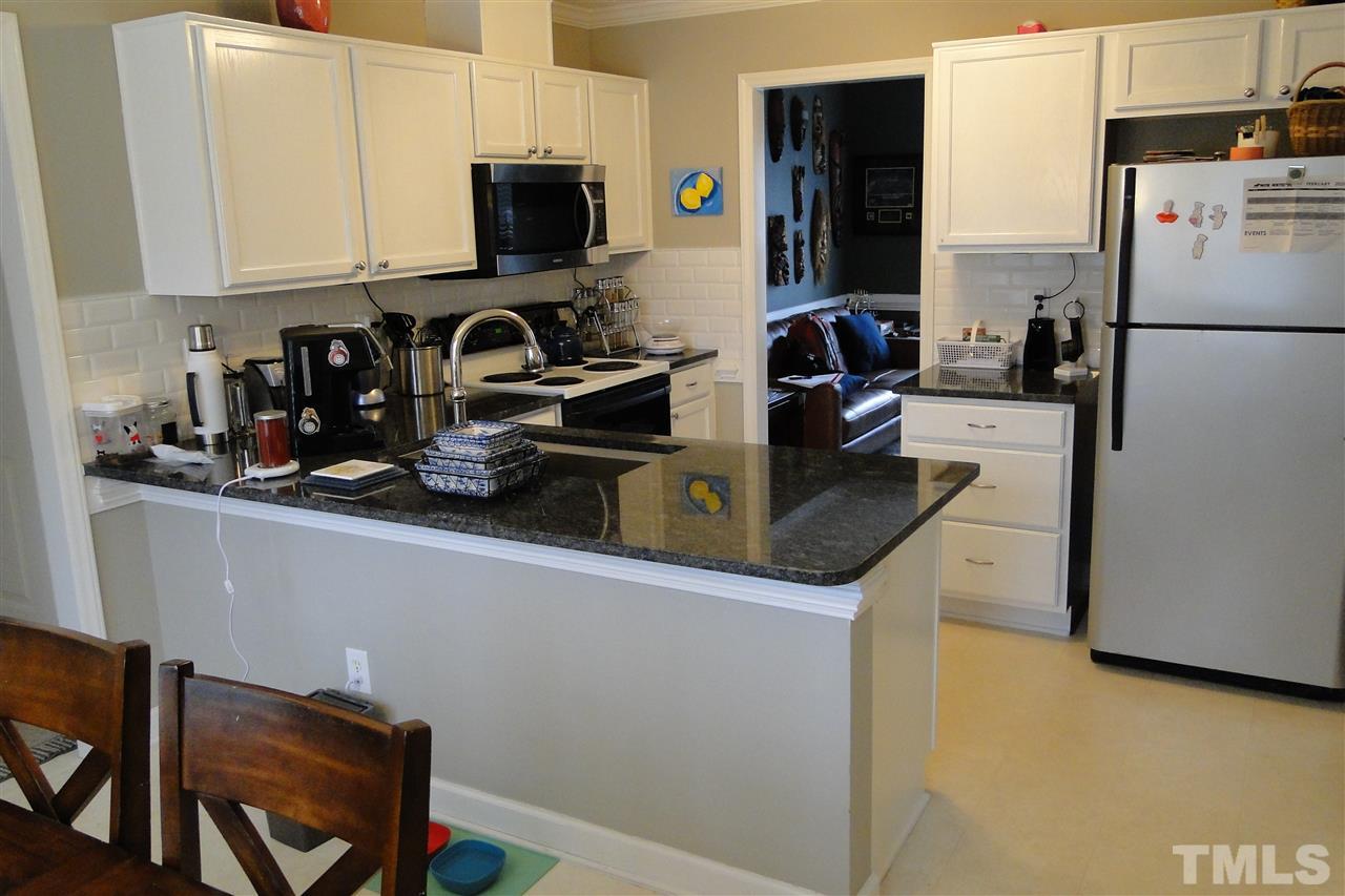 4105 Landrum Lane Raleigh, NC 27616 - Photo 11 of 29 a kitchen with stainless steel appliances granite countertop a refrigerator and a stove top oven