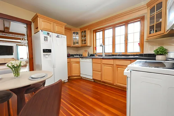 a kitchen with a sink appliances cabinets and a dining table