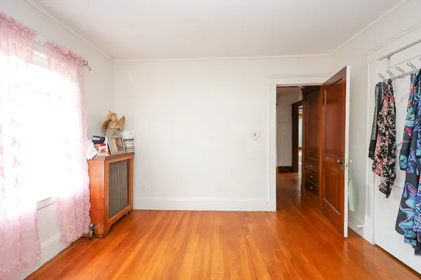a view of empty room with wooden floor and closet