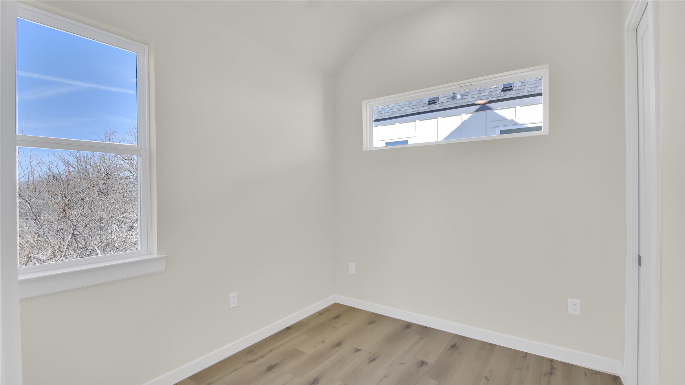 6802 Montana Street, Unit 1 Austin, TX 78741 - Photo 17 of 20 Empty room with wood finished floors and vaulted ceiling
