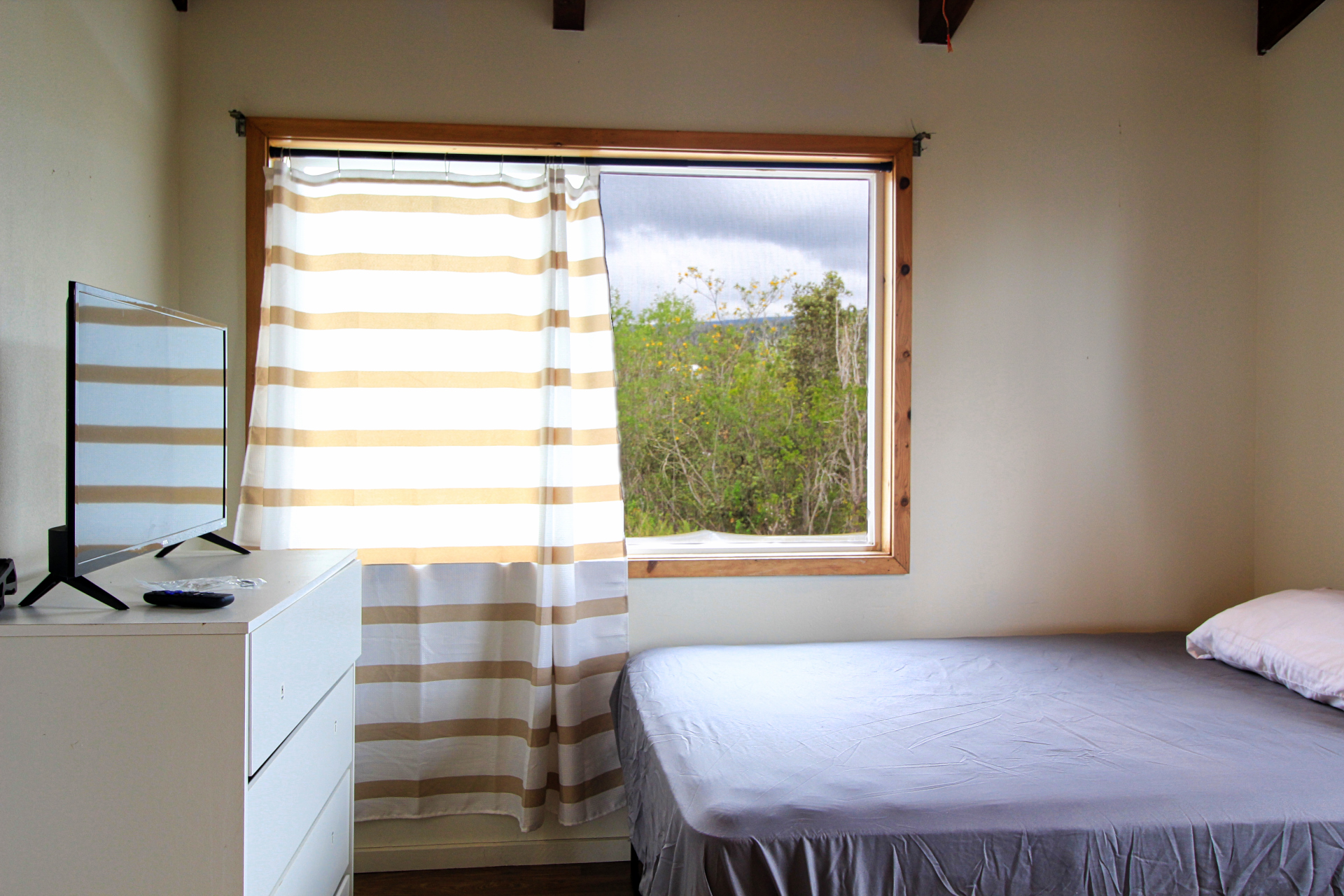92-1435 Aloha Boulevard Ocean View, HI 96704 - Photo 24 of 28 a bedroom with a bed and a window
