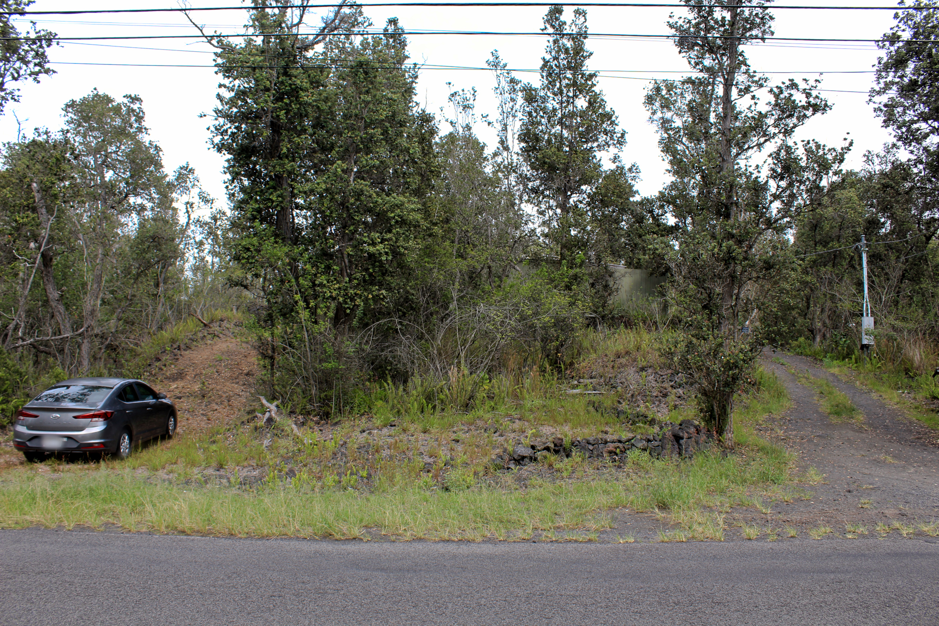 92-1435 Aloha Boulevard Ocean View, HI 96704 - Photo 5 of 28 a view of a car parked on the side of a road with trees
