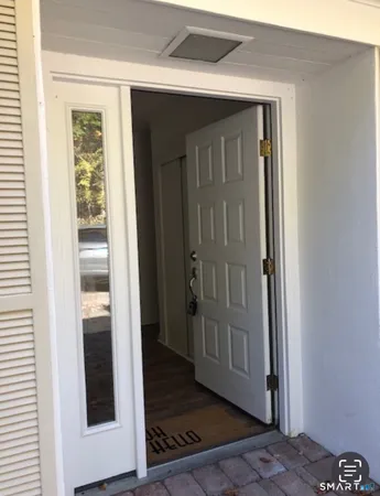 a view of a hallway with wooden floor and a cabinet