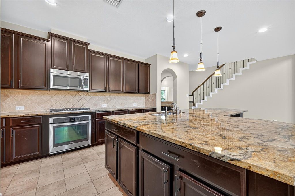 22743 Adrift Row Lane Porter, TX 77365 - Photo 13 of 33 a kitchen with kitchen island granite countertop a sink cabinets and stainless steel appliances