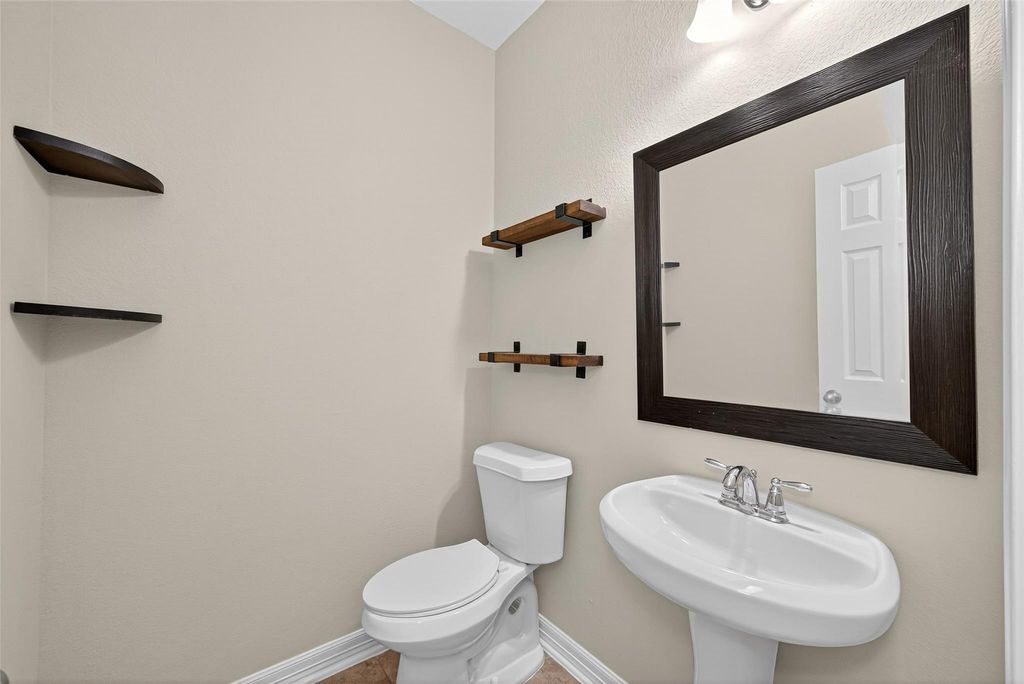 22743 Adrift Row Lane Porter, TX 77365 - Photo 16 of 33 a bathroom with a toilet a sink and mirror