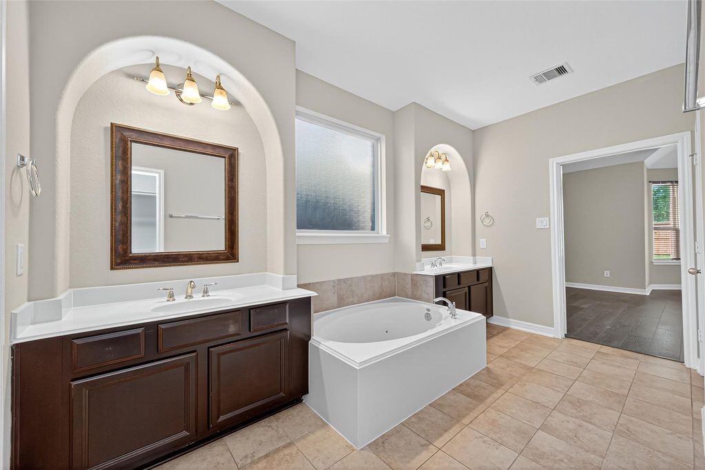 22743 Adrift Row Lane Porter, TX 77365 - Photo 27 of 33 a spacious bathroom with a double vanity sink mirror and bathtub