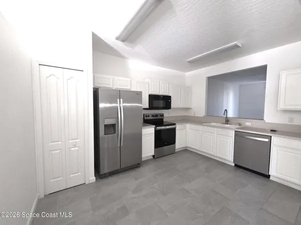 a large kitchen with cabinets and stainless steel appliances
