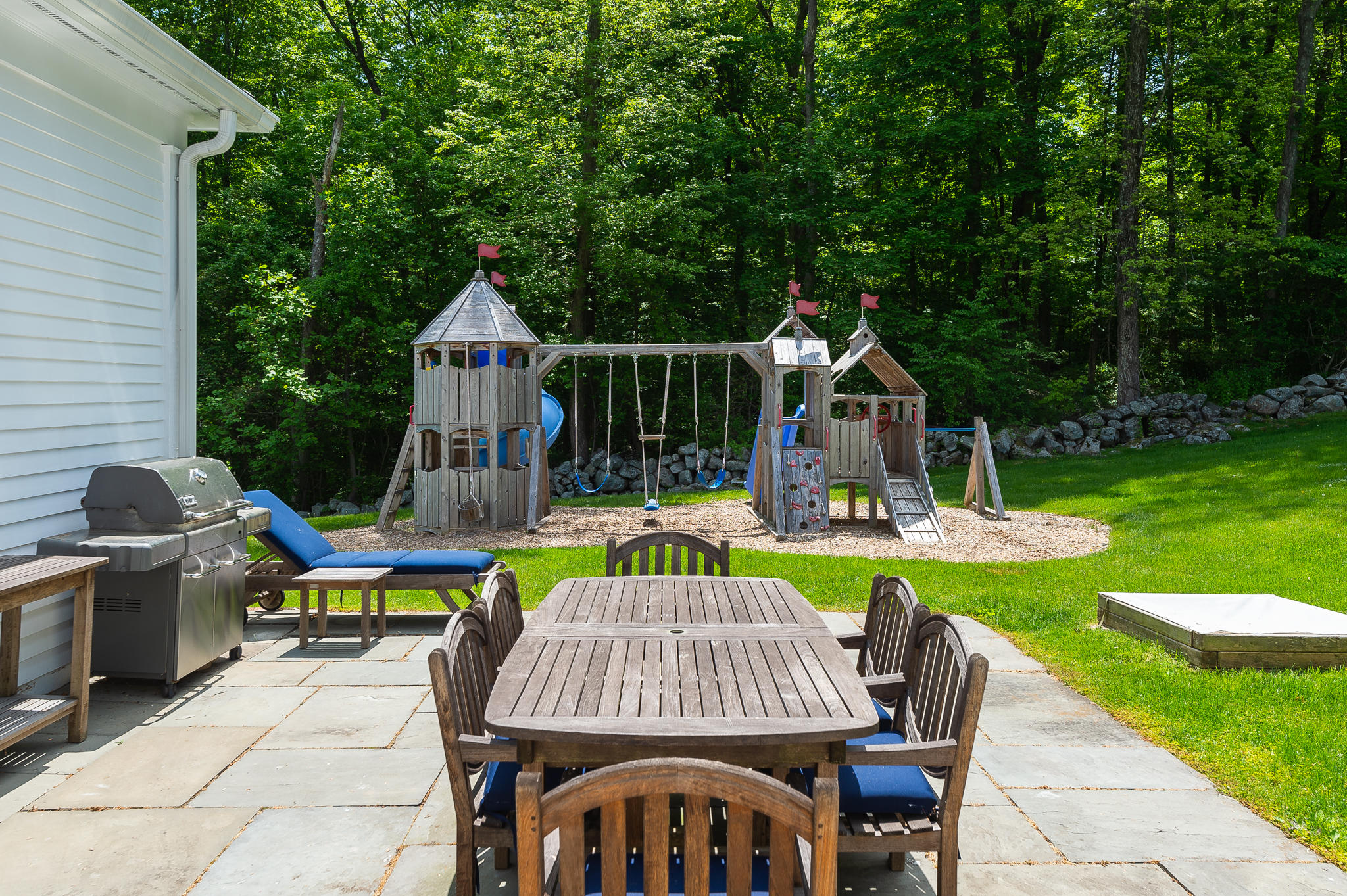 465 North Wilton Road New Canaan, CT 06840 - Photo 54 of 64 a view of a chair and table on the patio in front of the house