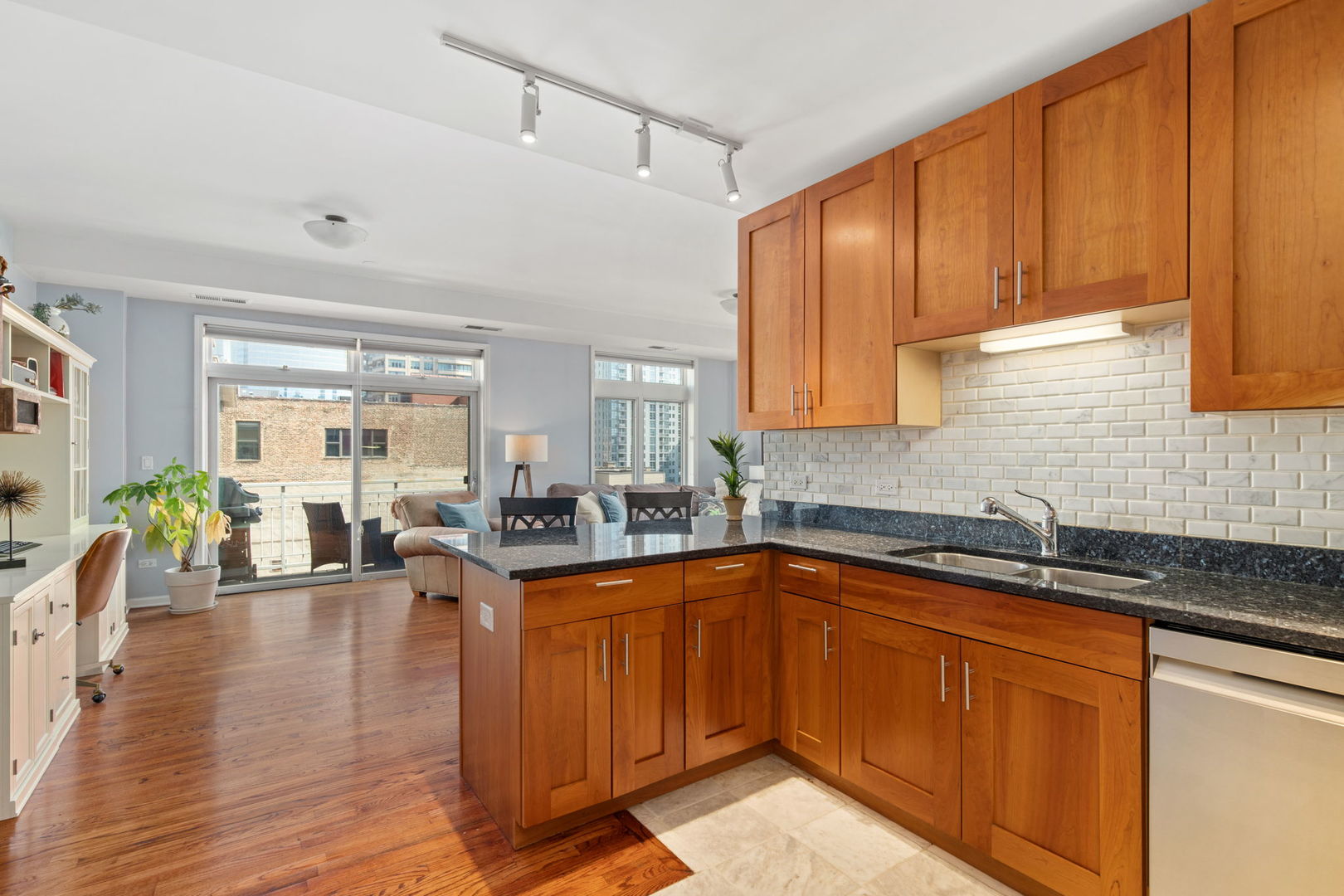 657 West Fulton Street, Unit 705 Chicago, IL 60661 - Photo 12 of 24 a kitchen with granite countertop a sink dishwasher stove and cabinets with wooden floor