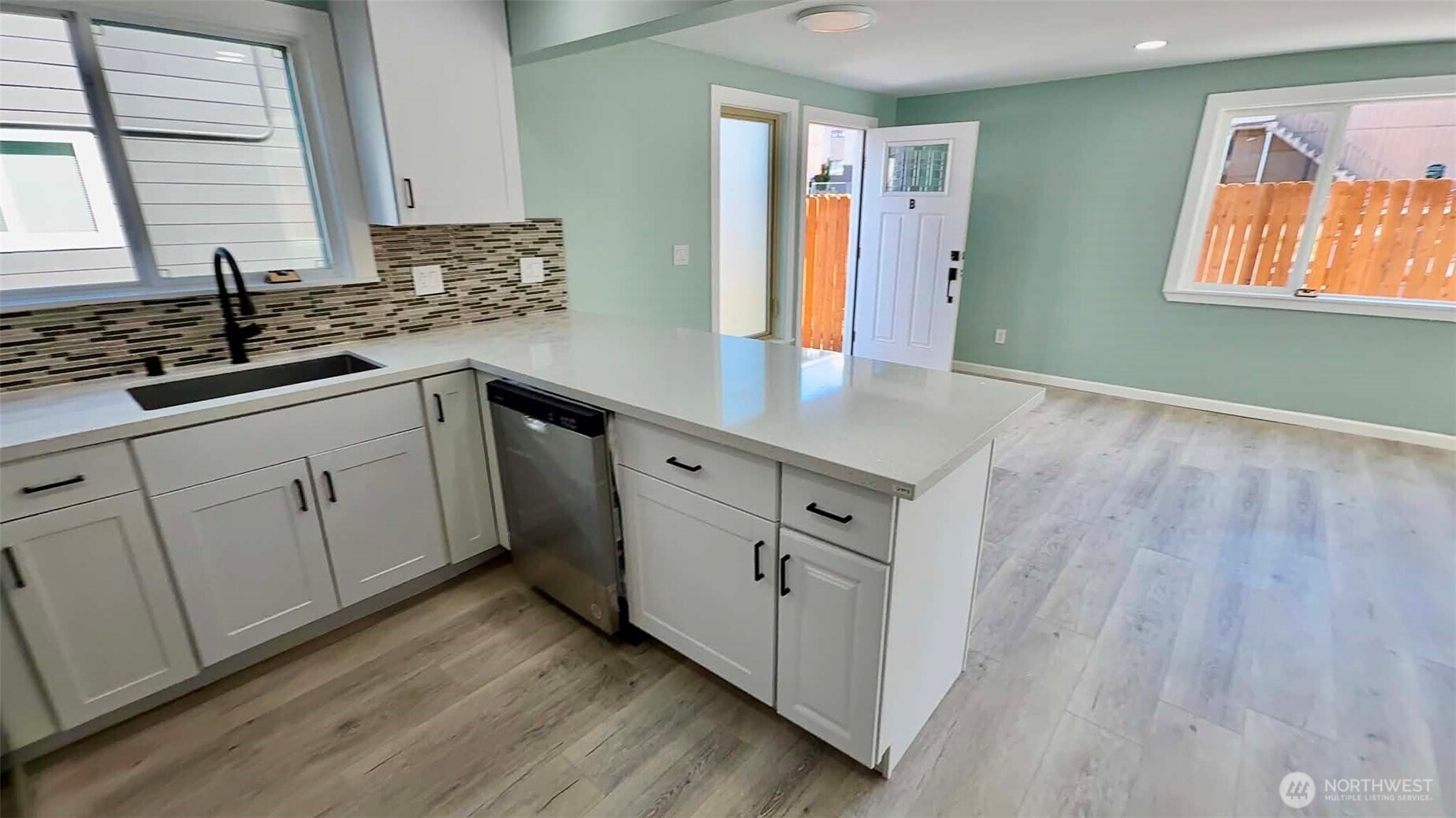 9040 17th Avenue Southwest Seattle, WA 98106 - Photo 22 of 34 a kitchen with sink cabinets and wooden floor