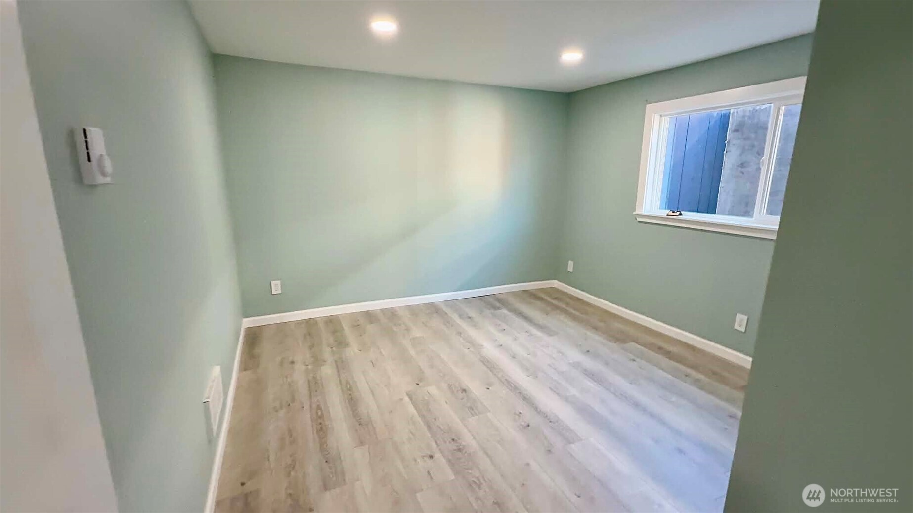 9040 17th Avenue Southwest Seattle, WA 98106 - Photo 27 of 34 an empty room with wooden floor and windows