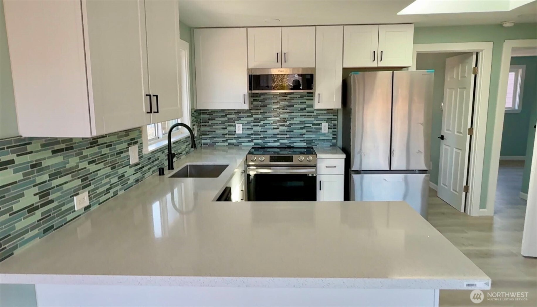 9040 17th Avenue Southwest Seattle, WA 98106 - Photo 5 of 34 a kitchen with stainless steel appliances a refrigerator a sink a stove a microwave and island