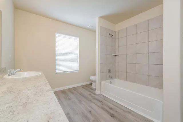 a bathroom with a granite countertop bathtub a sink and a shower