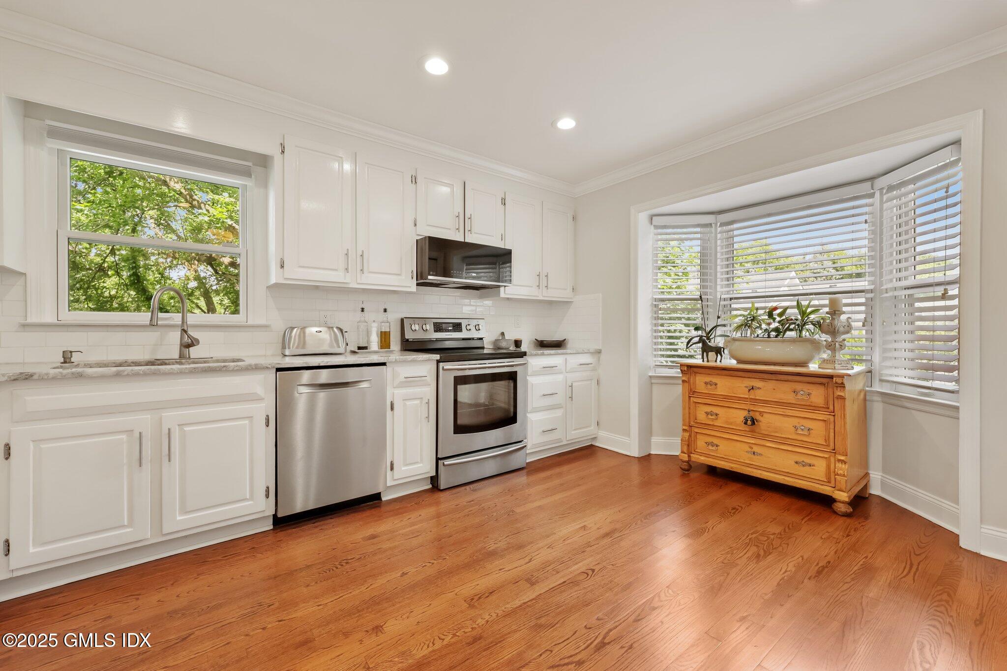 172 Field Point Road, Unit 9 Greenwich, CT 06830 - Photo 11 of 20 a kitchen with white cabinets and appliances