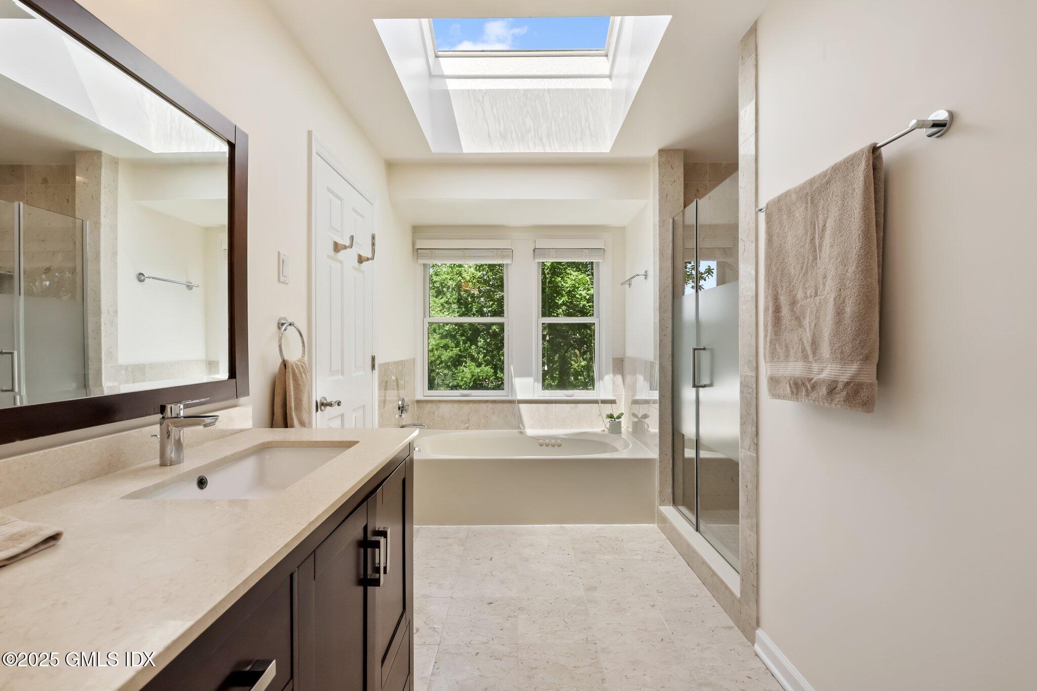 172 Field Point Road, Unit 9 Greenwich, CT 06830 - Photo 15 of 20 a bathroom with a tub sink and mirror