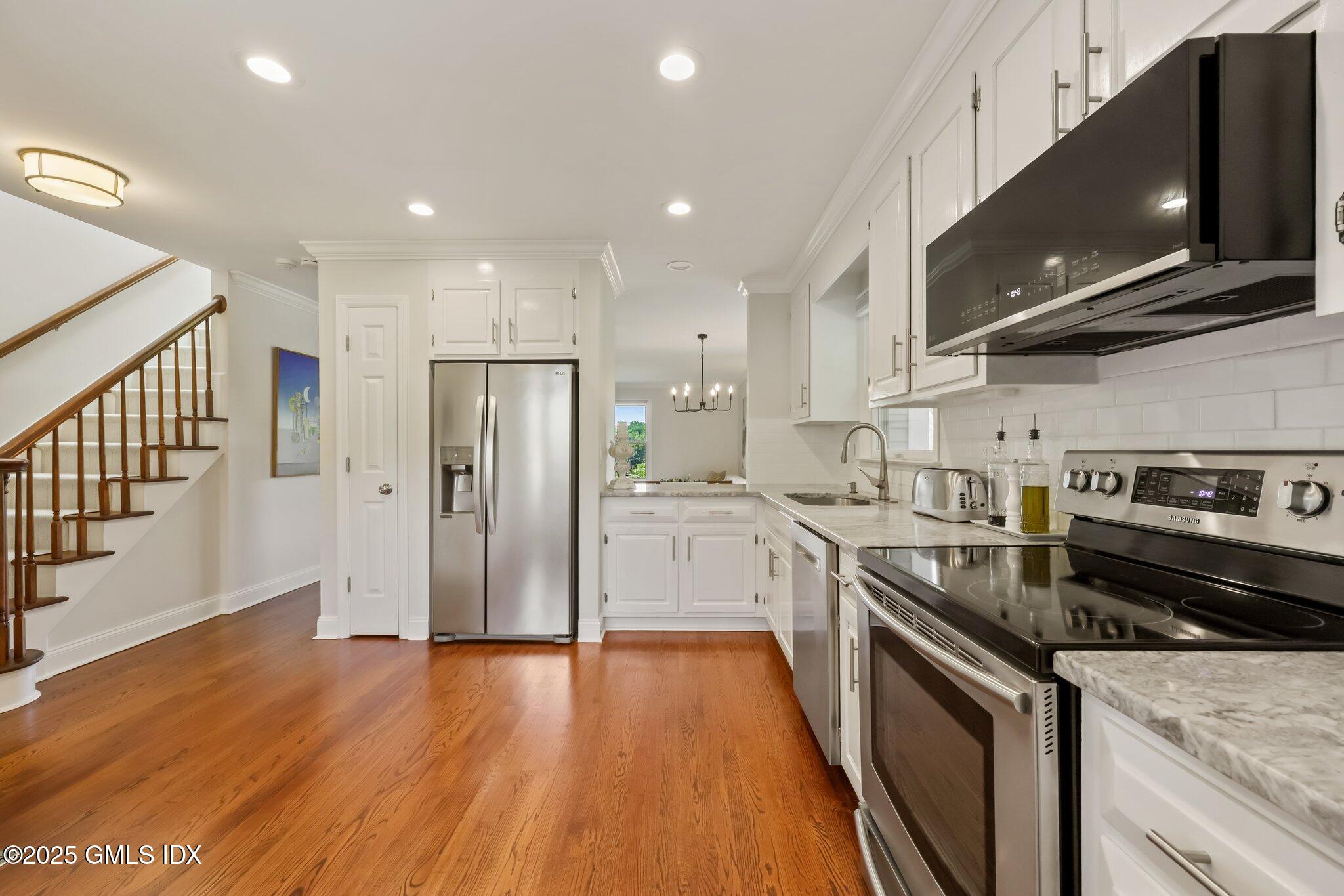 172 Field Point Road, Unit 9 Greenwich, CT 06830 - Photo 8 of 20 a kitchen with stainless steel appliances granite countertop a stove a refrigerator and a microwave