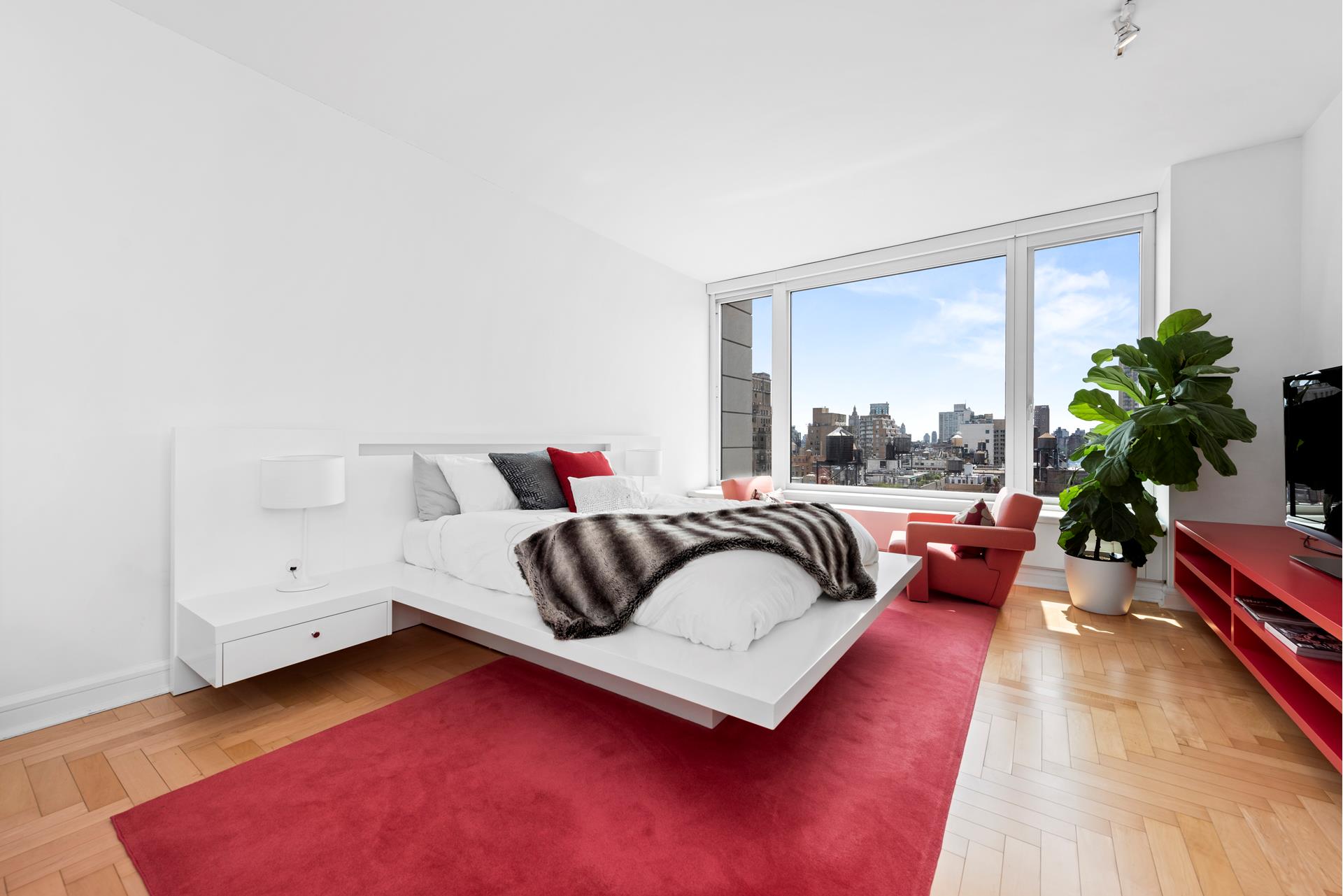 240 Riverside Boulevard, Unit 21C Manhattan, NY 10069 - Photo 10 of 32 a bedroom with furniture and a large window