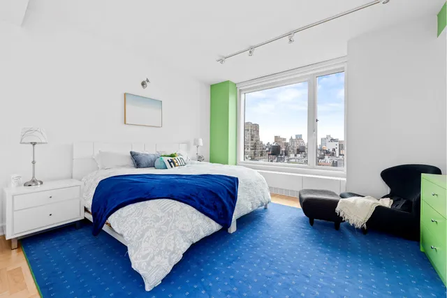 a bedroom with furniture and a large window