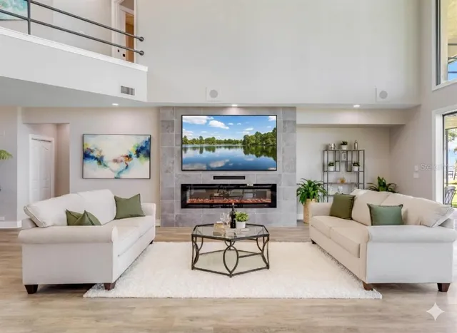 a kitchen with stainless steel appliances granite countertop a stove a sink a refrigerator and white cabinets with wooden floor