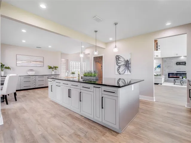 a large white kitchen with a large window and stainless steel appliances
