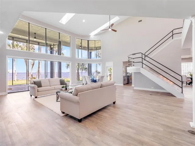 a view of a living room with a large window and kitchen floor