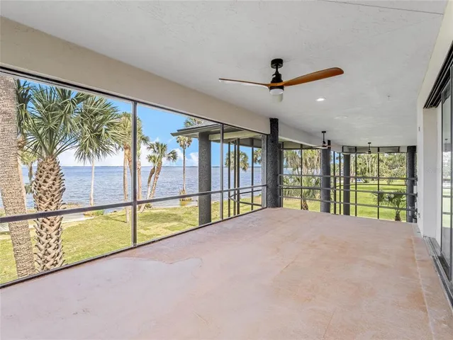 a view of a hallway with wooden floor and a bathroom