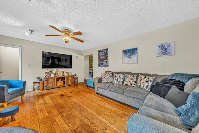 a living room with furniture kitchen view and a flat screen tv