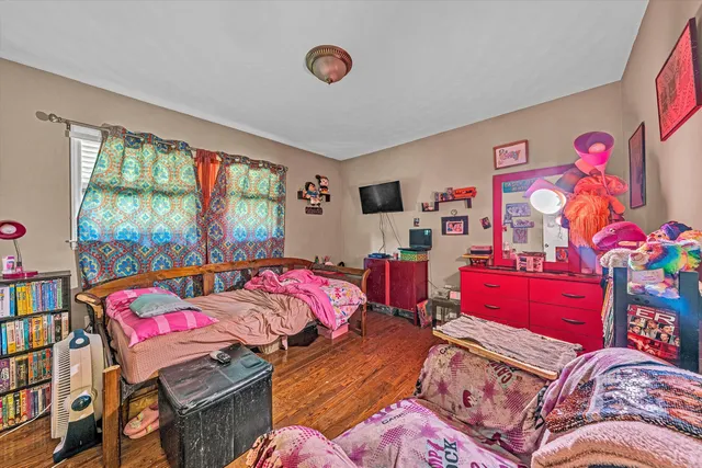a bedroom with a bed and a dresser next to a window