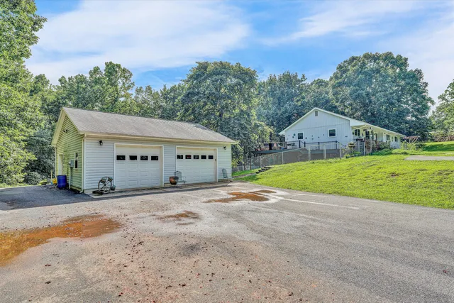 a view of a house with a yard and large trees