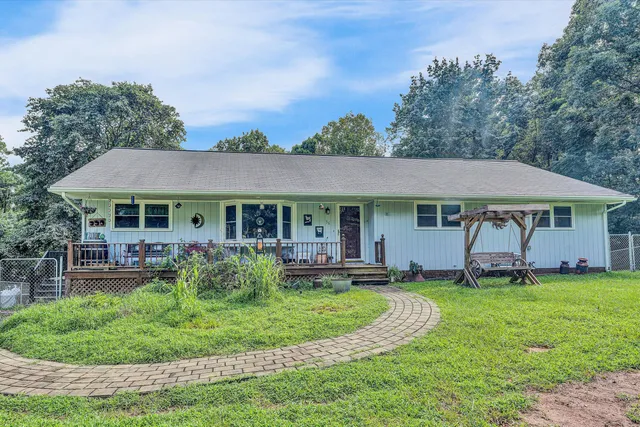 a view of a house with a yard table and chairs under an umbrella