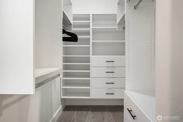 a view of walk in closet with empty racks