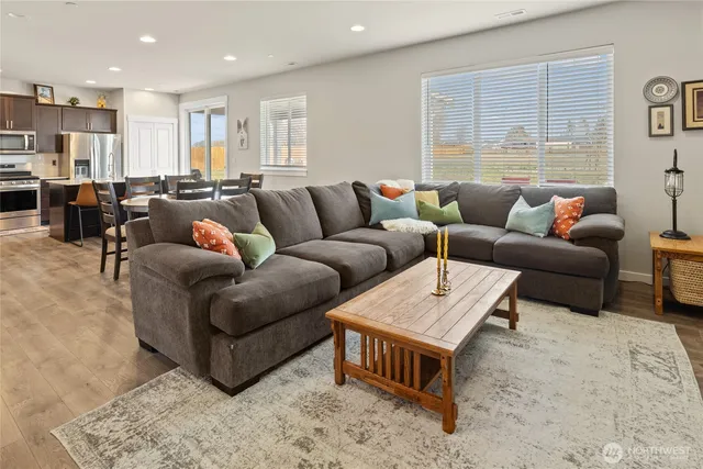 a living room with furniture kitchen view and a window