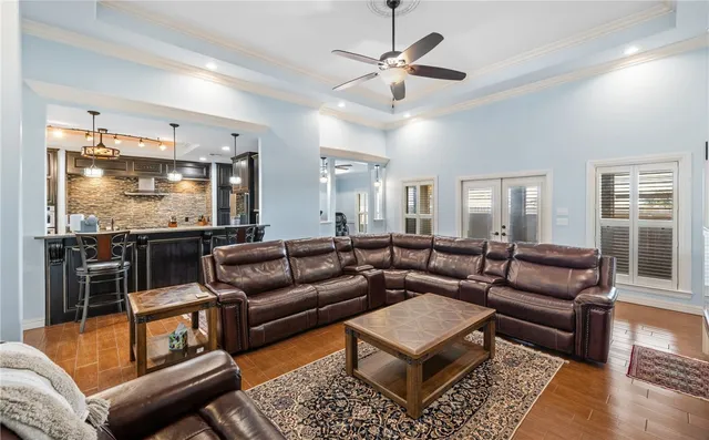 a living room with furniture ceiling fan and a flat screen tv