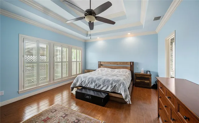 a bed sitting in a spacious bedroom next to a window