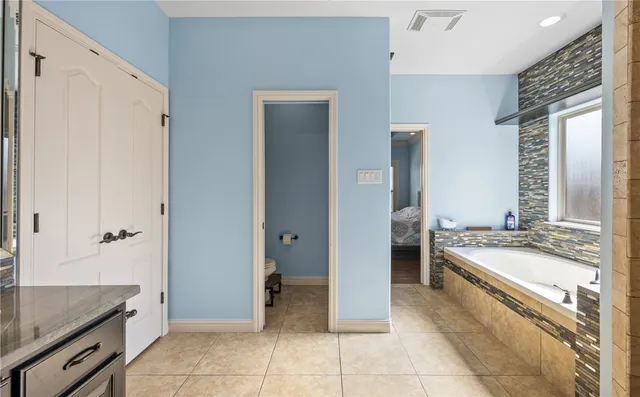 a spacious bathroom with a granite countertop tub sink and mirror