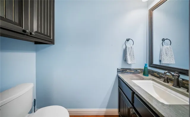 a bathroom with a sink a toilet and mirror